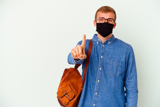 Uomo caucasico del giovane studente che studia tedesco isolato sul muro bianco che mostra il numero uno con il dito.