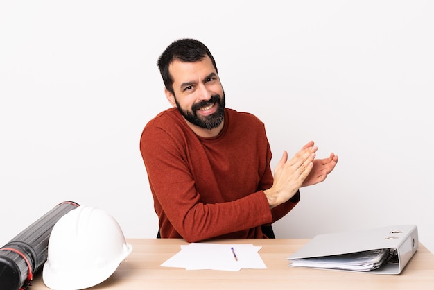 Uomo caucasico dell'architetto con la barba in un applauso della tavola.