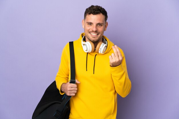 Uomo caucasico di giovane sport con la parete viola isolata borsa che fa gesto dei soldi