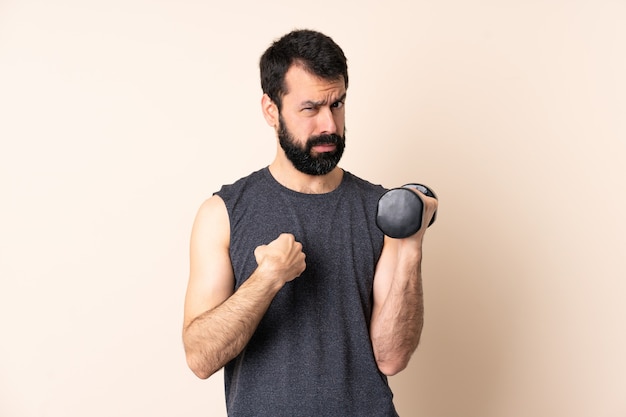 Uomo caucasico di sport con la barba che fa sollevamento pesi isolato