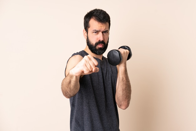 Uomo caucasico di sport con la barba che fa sollevamento pesi