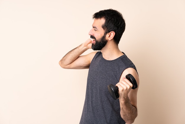 Uomo caucasico di sport con la barba che fa sollevamento pesi