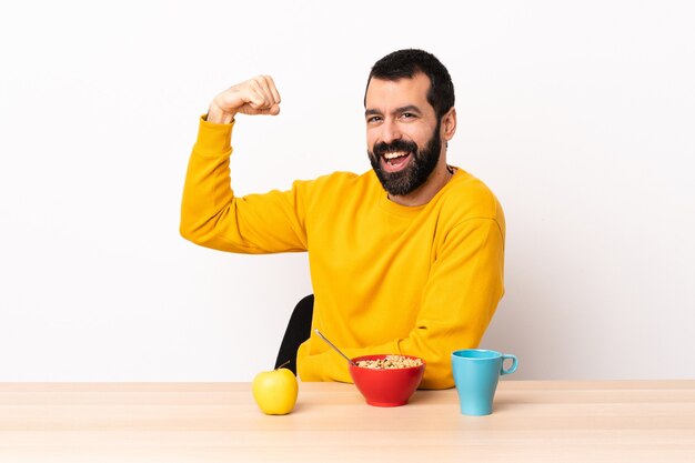 Uomo caucasico facendo colazione in un tavolo facendo un gesto forte