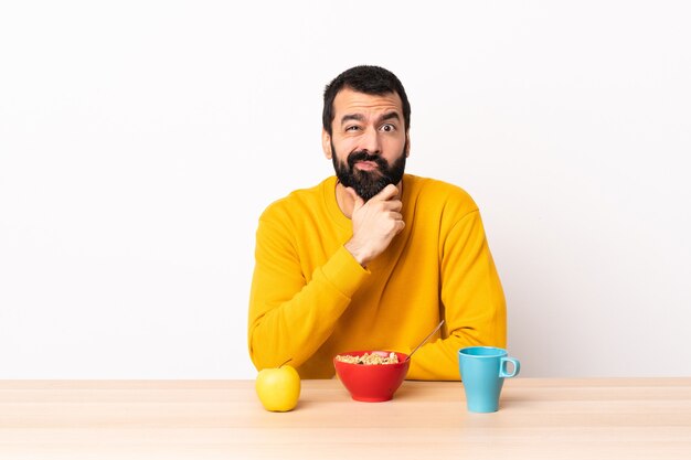 Uomo caucasico facendo colazione in un tavolo pensando.