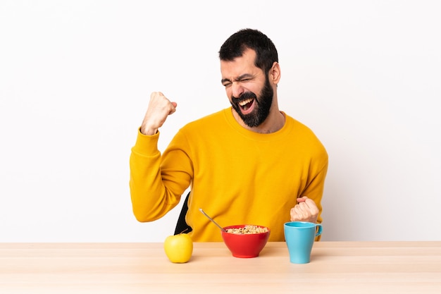 Uomo caucasico facendo colazione in un tavolo per celebrare una vittoria.