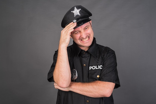 Uomo caucasico frustrato che indossa un costume uniforme della polizia in studio