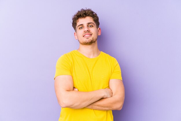 Uomo caucasico giovane dei capelli ricci biondi sospettoso, incerto, che ti esamina.