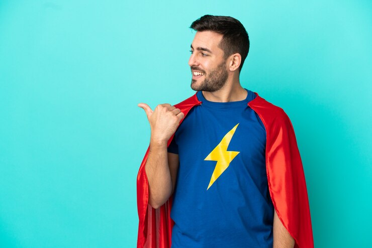 Foto uomo caucasico super eroe isolato su sfondo blu che punta al lato per presentare un prodotto