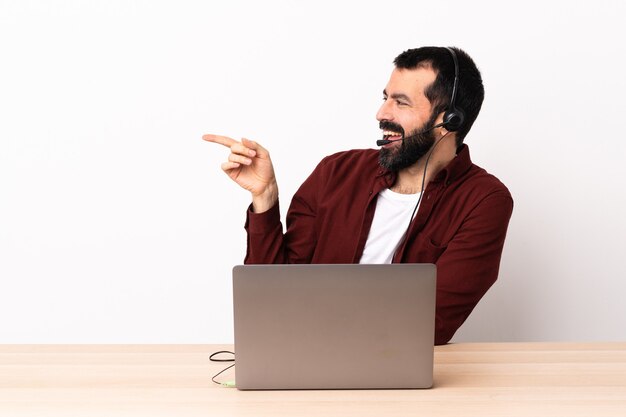 Uomo caucasico telemarketer che lavora con un auricolare e un computer portatile