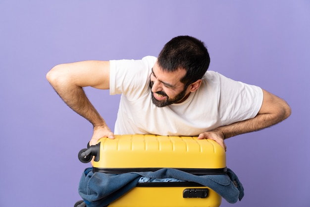 Uomo caucasico viaggiatore con una valigia piena di vestiti isolati