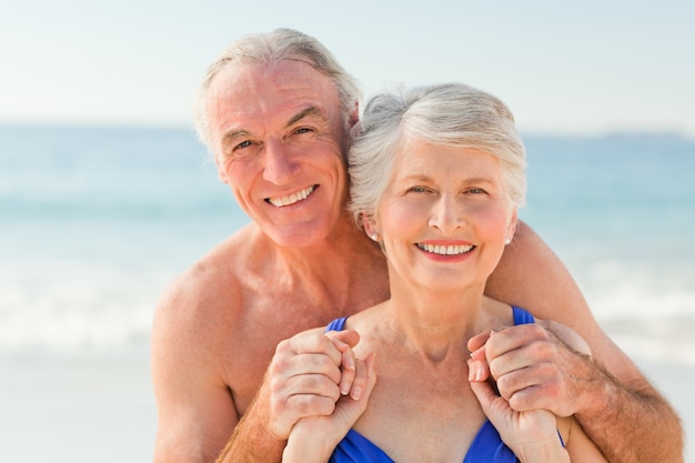 Uomo che abbraccia sua moglie in spiaggia