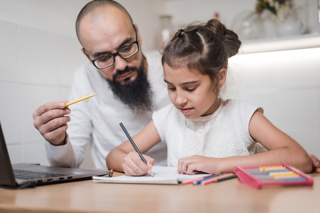 Uomo che aiuta la figlia con i compiti.