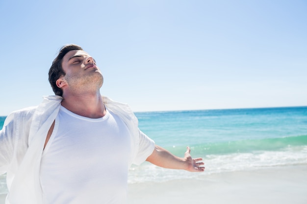 Uomo che allunga le braccia davanti al mare