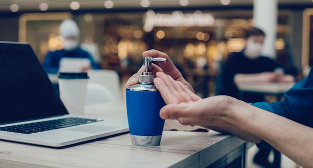 Uomo che applica un gel decontaminante alle sue mani