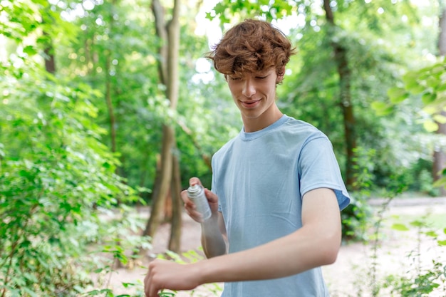 Uomo che applica un repellente per insetti contro zanzare e zecche sulle braccia durante l'escursione nella natura Protezione della pelle contro le punture di insetti