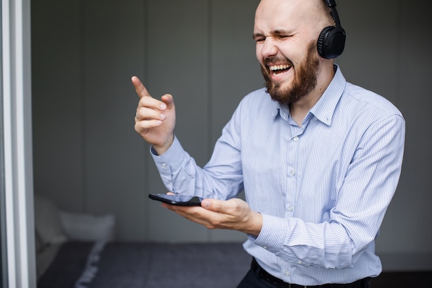 Uomo che ascolta la musica con le cuffie in soggiorno