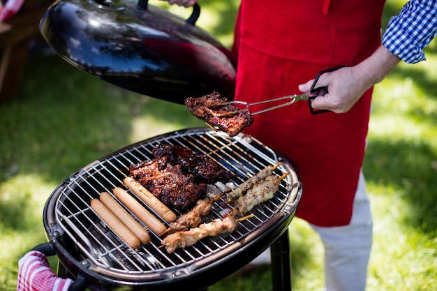 Uomo che barbequing nel parco