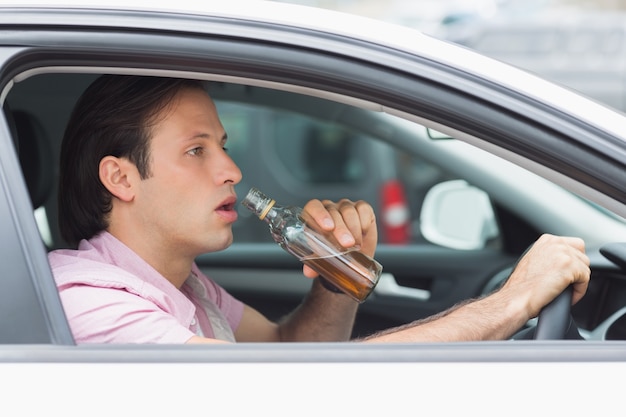 Uomo che beve alcol durante la guida