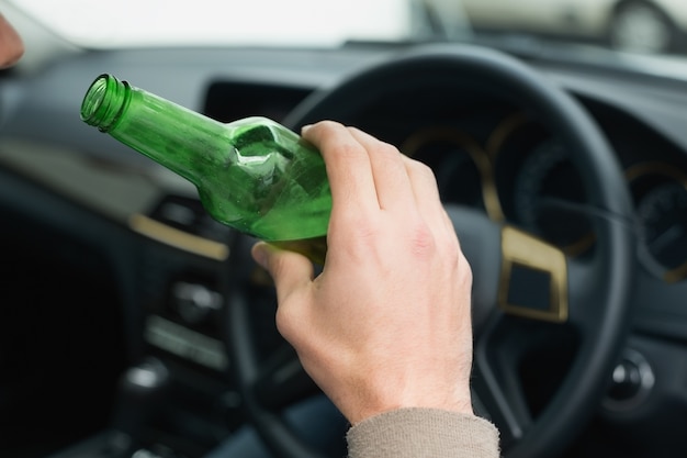 Uomo che beve birra durante la guida