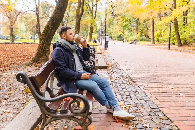 Uomo che beve caffè all'aperto stagione autunnale