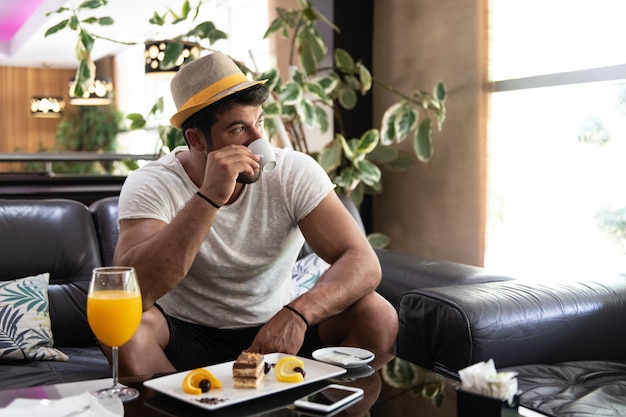 Uomo che beve caffè in un bar della hall dell'hotel