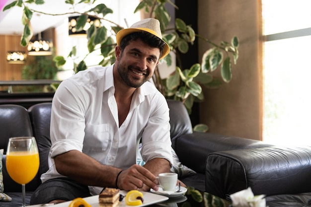 Uomo che beve caffè in un bar della hall dell'hotel