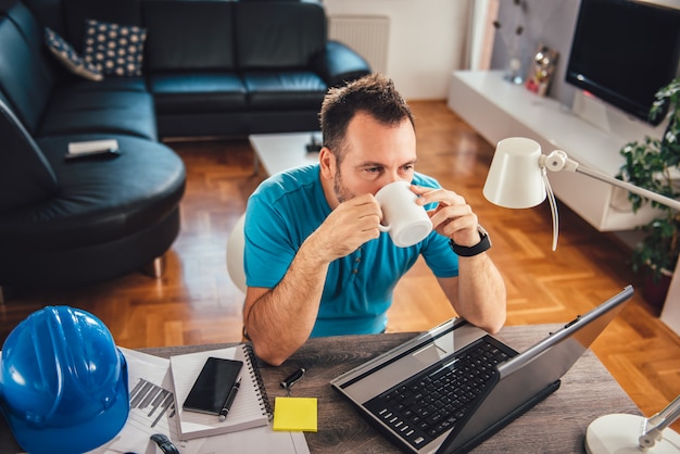 Uomo che beve l'ufficio del caffè a casa