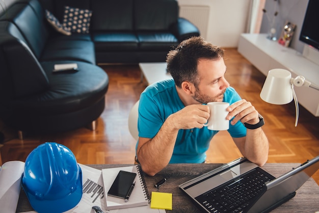 Uomo che beve l'ufficio del caffè a casa