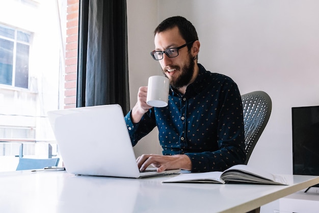 Uomo che beve un caffè durante il telelavoro