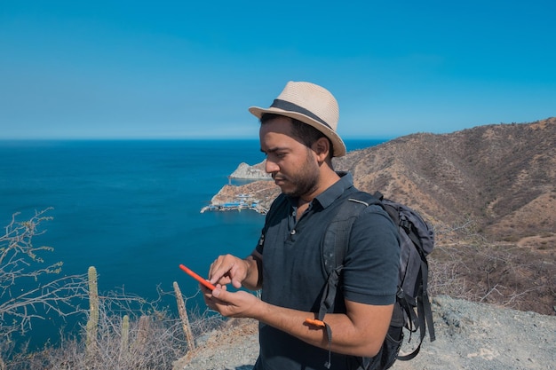 Uomo che cammina che usa lo smartphone per scattare foto, viaggiare e il concetto di stile di vita attivo