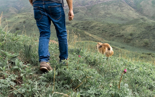 Uomo che cammina con il cane in montagna