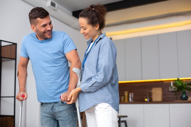 Uomo che cammina con le stampelle colpo medio medium