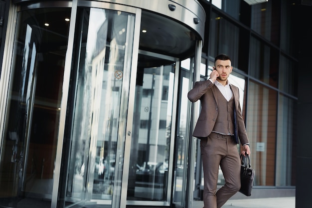 Uomo che cammina fuori da un ufficio commerciale. uomo d'affari che cammina fuori dal centro ufficio moderno.