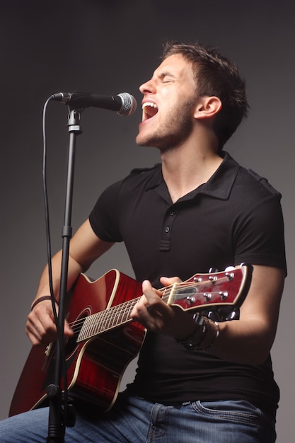 Uomo che canta e suona una chitarra