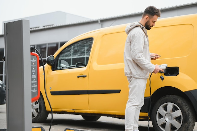 Uomo che carica auto elettrica dal lavoro