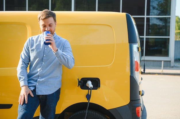 Uomo che carica la sua auto elettrica alla stazione di ricarica