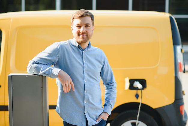 Uomo che carica un'auto elettrica vicino alla casa