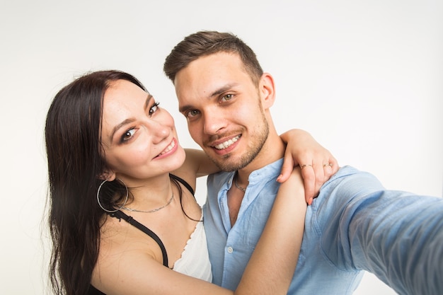 uomo che cattura selfie con la sua donna isolata su bianco