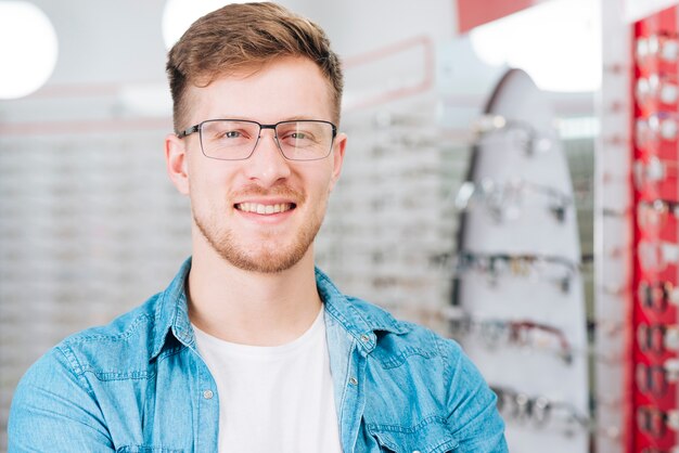 Uomo che cerca nuovi occhiali all&#39;optometrista