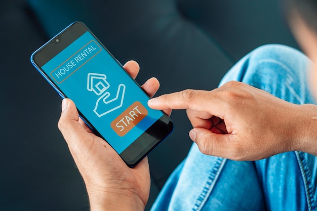 uomo che cerca un appartamento sul sito web di proprietà in affitto tramite closeup dello smartphone