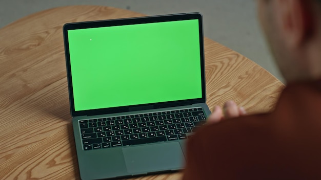 Uomo che chiama video, portatile a schermo verde, gesticola a casa, businessman che parla.