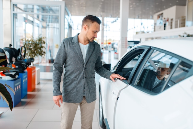 Uomo che compra una nuova auto in showroom.