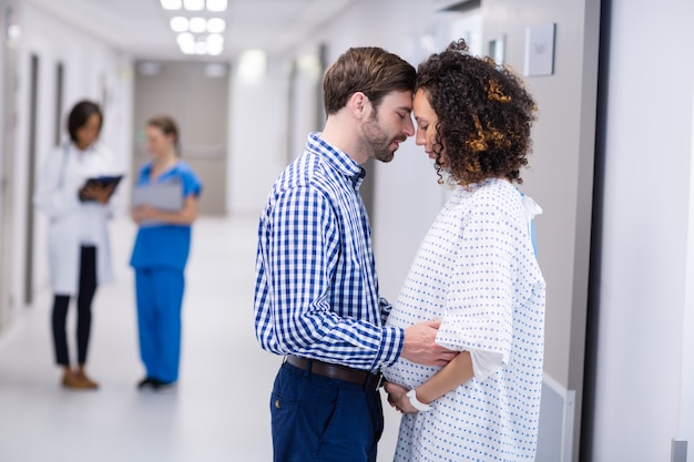 Uomo che conforta donna incinta in corridoio