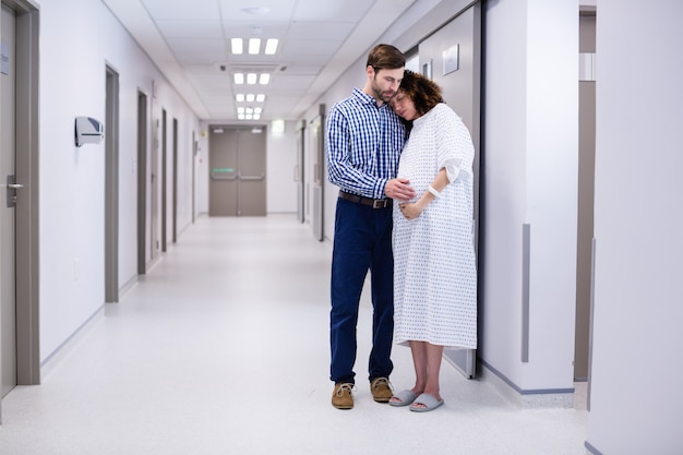 Uomo che conforta donna incinta in corridoio