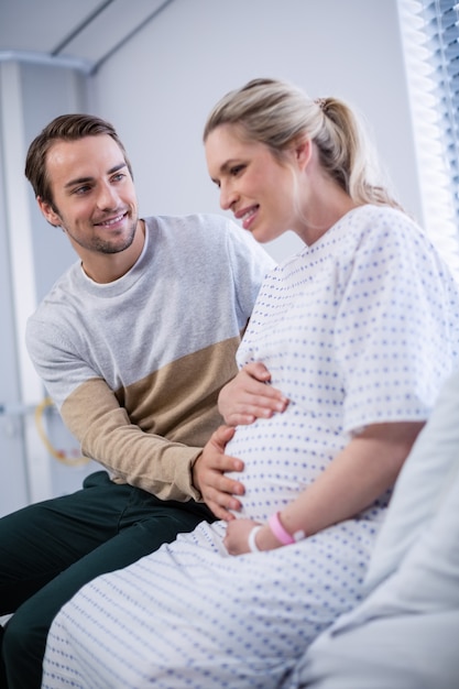 Uomo che conforta donna incinta in reparto