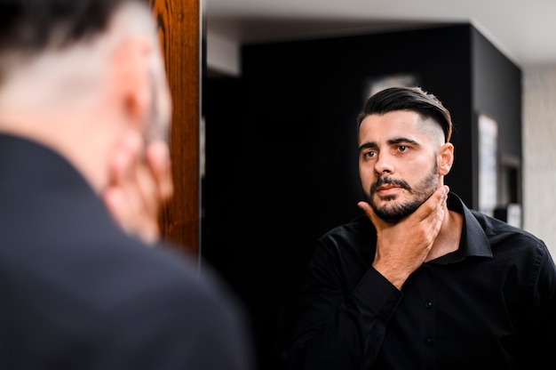 Uomo che controlla la barba allo specchio