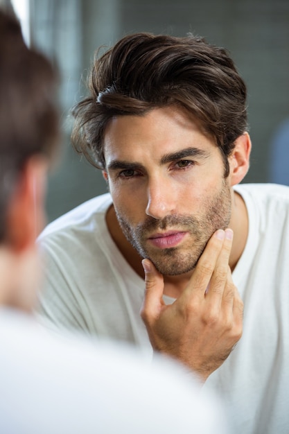 Uomo che controlla la sua stoppia in bagno