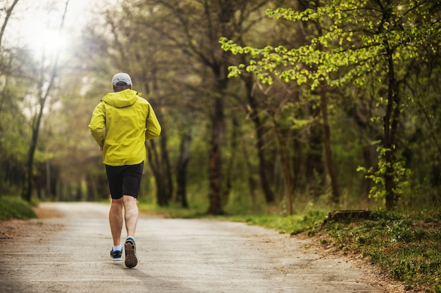 Uomo che corre al mattino in un parco