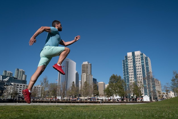 Uomo che corre all'aperto in città che fa jogging in un parco cittadino