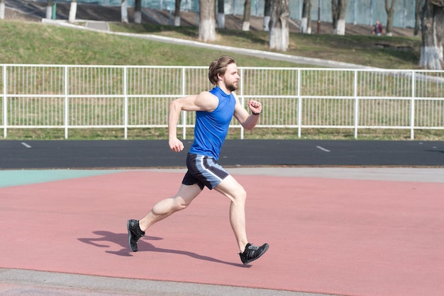 Uomo che corre nell'arena sportiva soleggiata sport all'aria aperta e ricreazione futuro e successo persone e velocità della natura e stile di vita sano